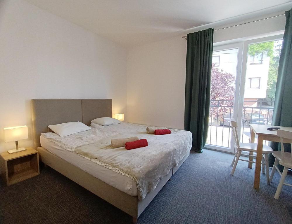 a bedroom with a bed with two red pillows on it at Firstroom Gdańsk in Gdańsk