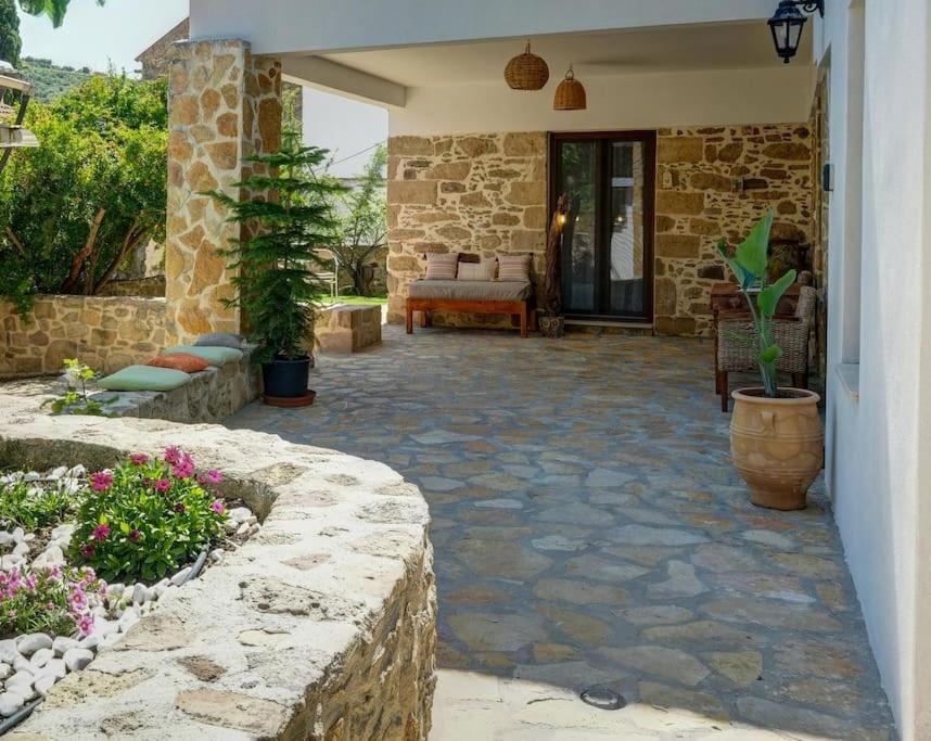 a patio with a stone walkway and a house at Apartments Panethimos 