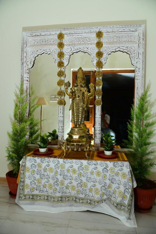 een tafel met een gouden standbeeld erop bij RAATREE in Mysore