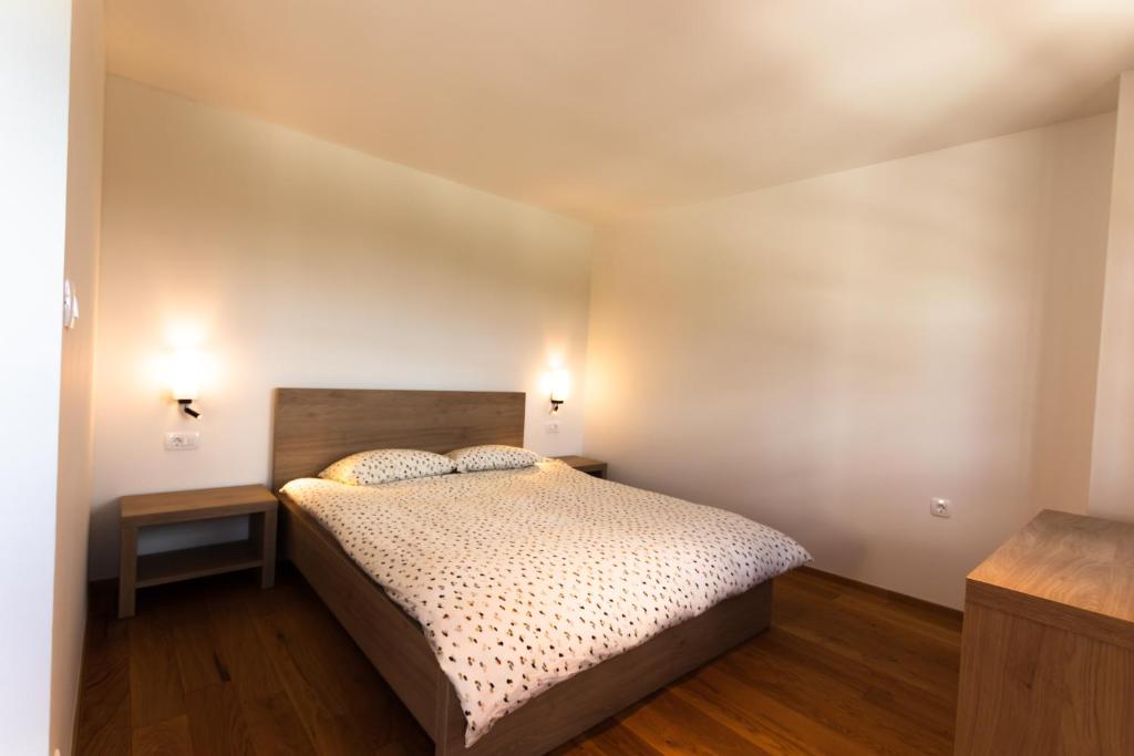 1 dormitorio con 1 cama y 2 mesitas de noche en Vinoteka Brda, en Šmartno