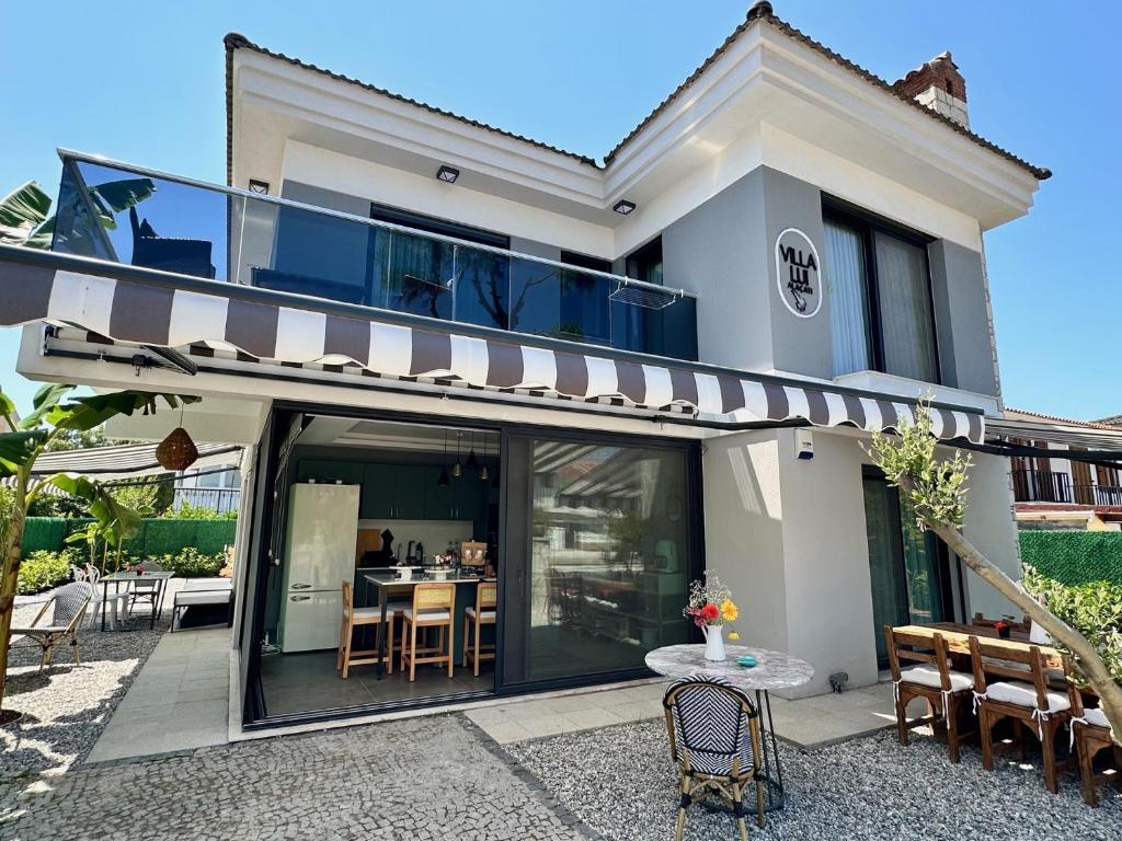 a house with a balcony with a table and chairs at Villa Lui Hotel Alaçatı in Ilıca