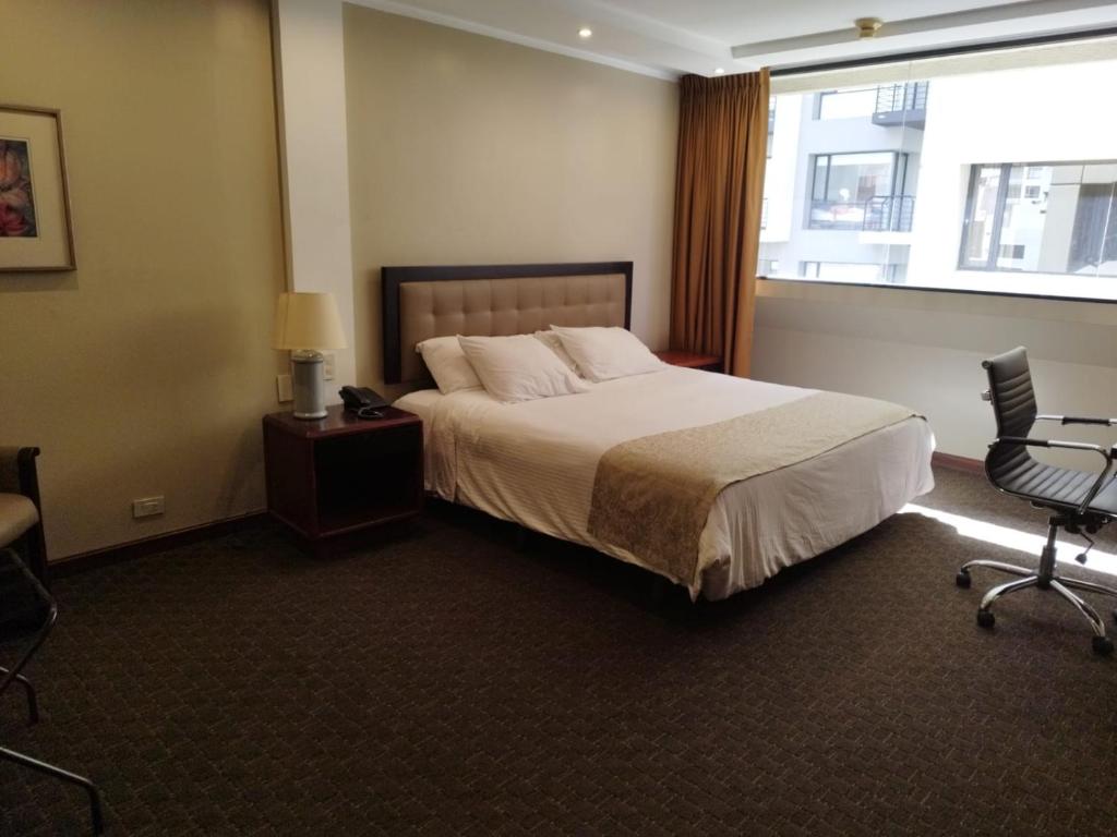 a hotel room with a bed and a window at Suite Akros in Quito