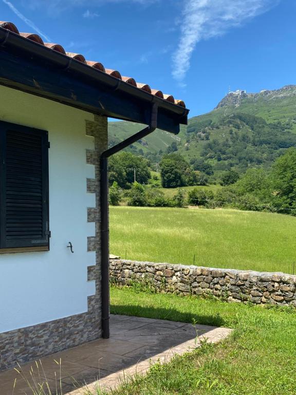 un edificio blanco con ventana y pared de piedra en Casa Rural Laurenea, en Alzate