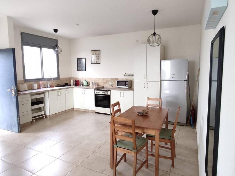 una cucina con tavolo, sedie e frigorifero di Desert View Home a Ashalim