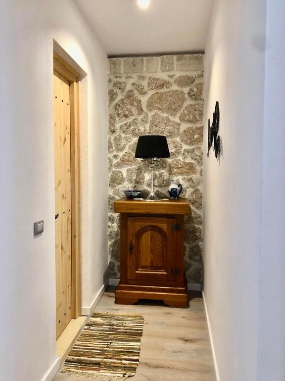 a hallway with a table with a lamp on it at Rahoni Park & Suites in Dhërmi