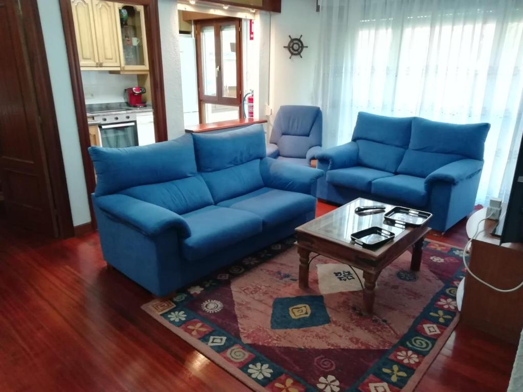 Sala de estar con sofás azules y mesa de centro en APARTAMENTO VALDEARENAS, en Renedo de Piélagos