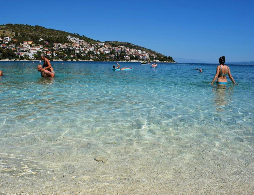 um grupo de pessoas na água em uma praia em Apartments Miki, Okrug Gornji, Trogir em Trogir