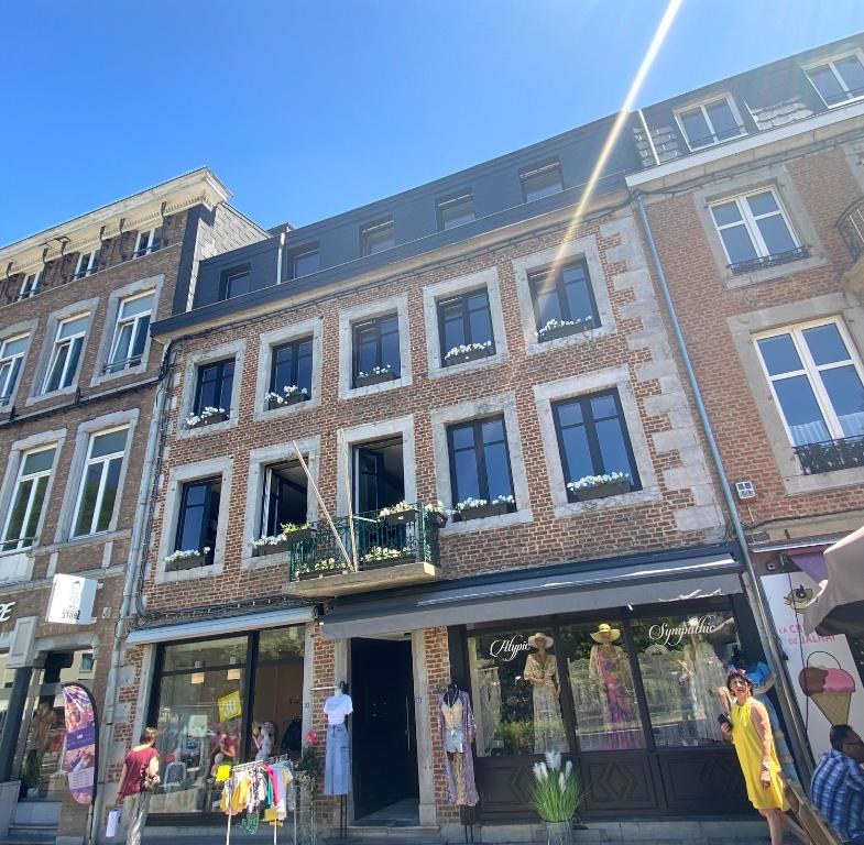 un bâtiment en briques dans une rue avec un magasin dans l'établissement Luxury Spa Hotel - Ardennes, à Spa