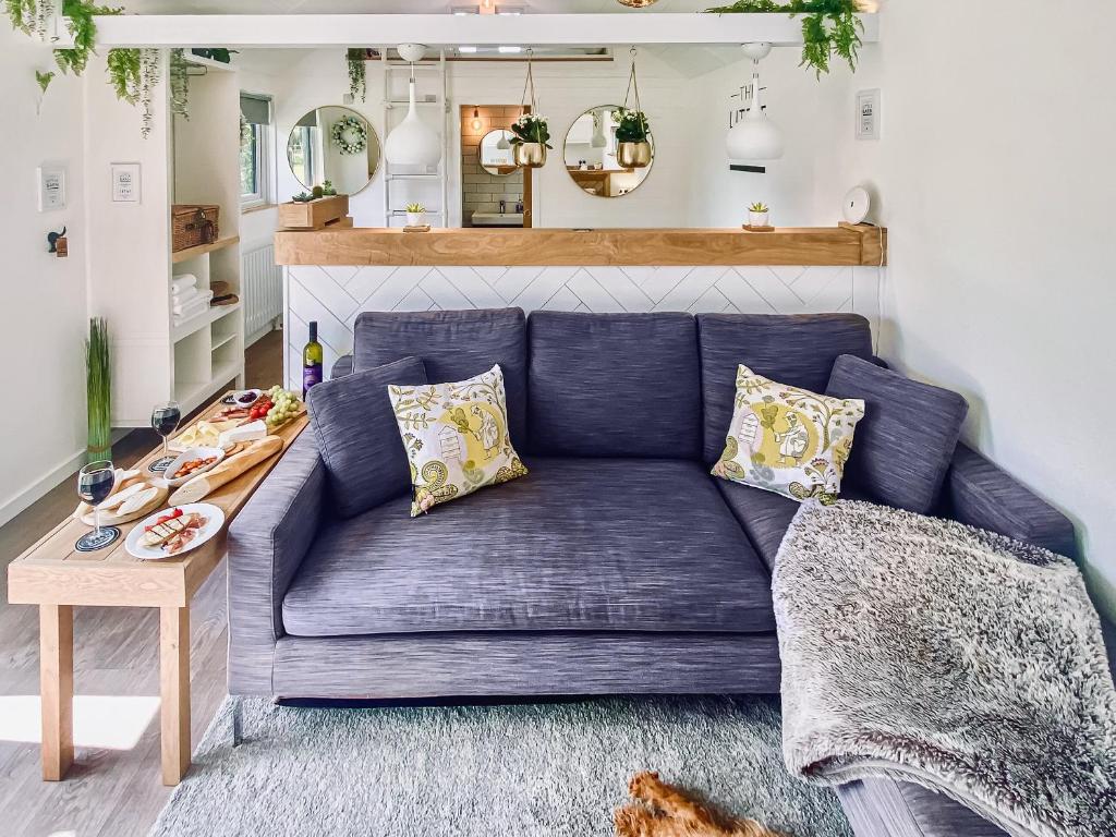 a blue couch in a living room with a table at The Little Barn in Hoxne