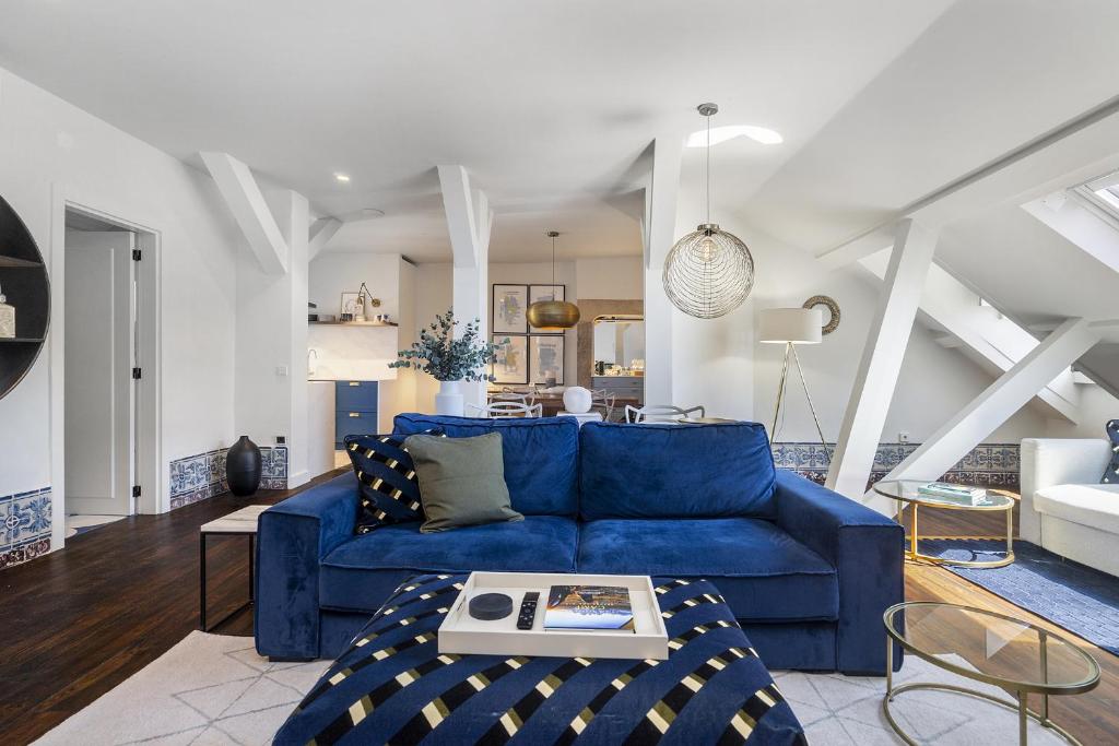 a living room with a blue couch and a table at Lisbon Downtown Luxury Family Residence in Lisbon