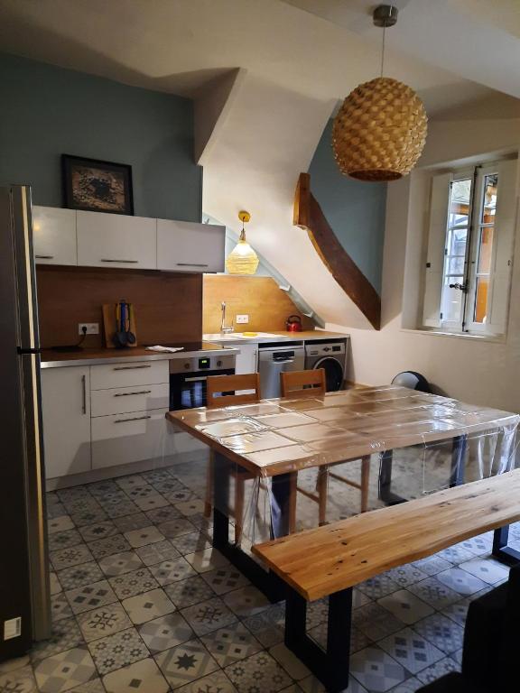 a kitchen with a wooden table in a kitchen at Le Cassandre in Givry