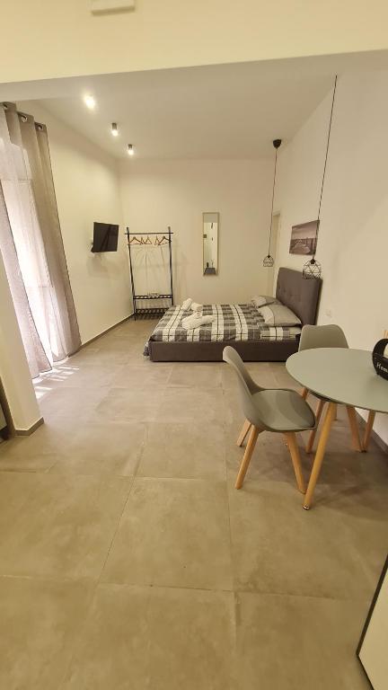 Habitación con cama, mesa y silla en Sweet Home Airport 2.0, en Catania