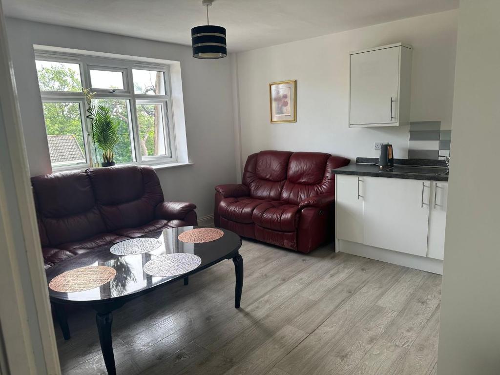 a living room with a couch and a table at Lovely 2 bedroom Flat at Palm Court in Bournemouth,5 minutes away from beach, whole flat is yours for the time you stayed in Bournemouth