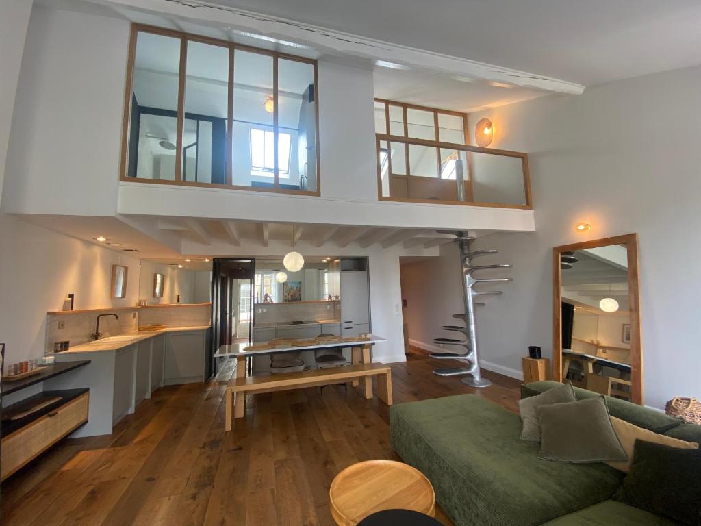 een woonkamer met een groene bank en een keuken bij Loft Cathédrale in Bayonne