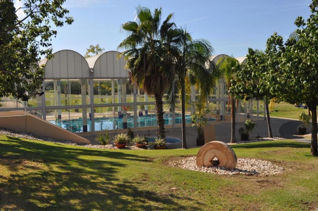 a building with a swimming pool in a park at Daissy house - דירה פרטית בנאות גולף in Caesarea