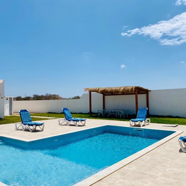 米多恩的住宿－Maison de Noé Djerba Midoun，一个带椅子的游泳池和一个凉亭