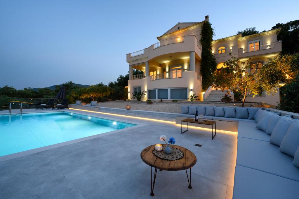 una casa grande con piscina frente a una casa en Aeras Luxury Villa, en Kastanéa