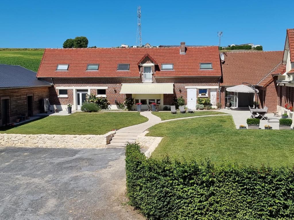 uma grande casa de tijolos com uma entrada em frente em Le Pré Fleuri em Curlu