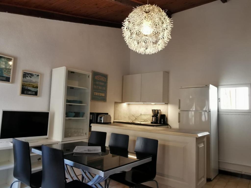 Il comprend une cuisine avec une table à manger et un lustre. dans l&#39;établissement Bel appartement dans le Centre Historique de Montpellier, à Montpellier