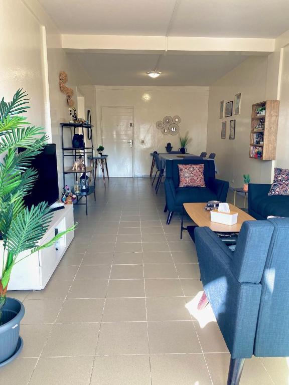 un soggiorno con divano blu e tavolo di Appartement: Dakar-Plateau a Dakar