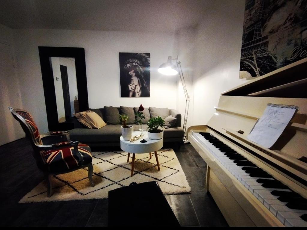 un soggiorno con divano e pianoforte di Appartement Disneyland Paris a Bussy-Saint-Georges