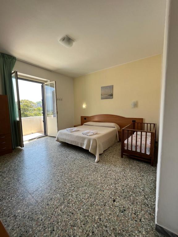 a bedroom with a bed and a sliding glass door at Hotel Valente in Ortona