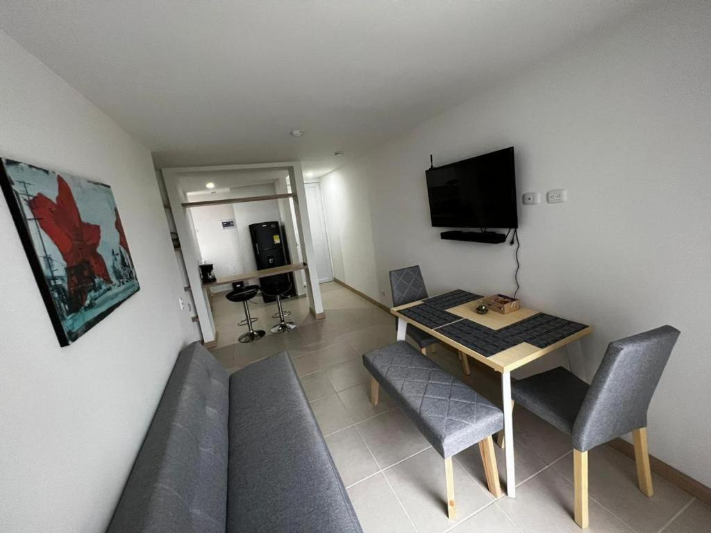 sala de estar con mesa, sillas y TV en Hermoso apartamento la Francia 3 habitaciones, en Manizales