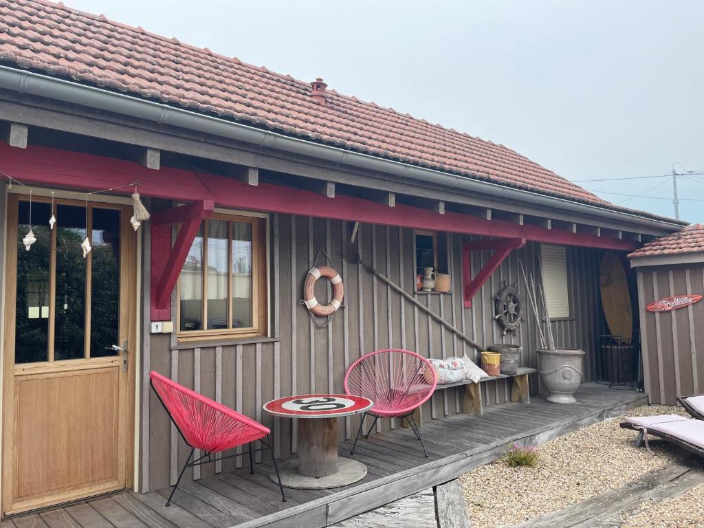 une maison avec deux chaises et une table sur une terrasse dans l'établissement La Cabane, à Andernos-les-Bains
