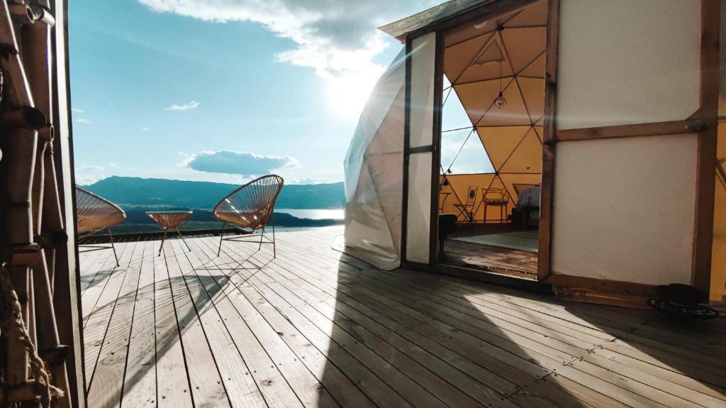 a balcony with chairs and a view of the ocean at Andes Glamping in Guatavita