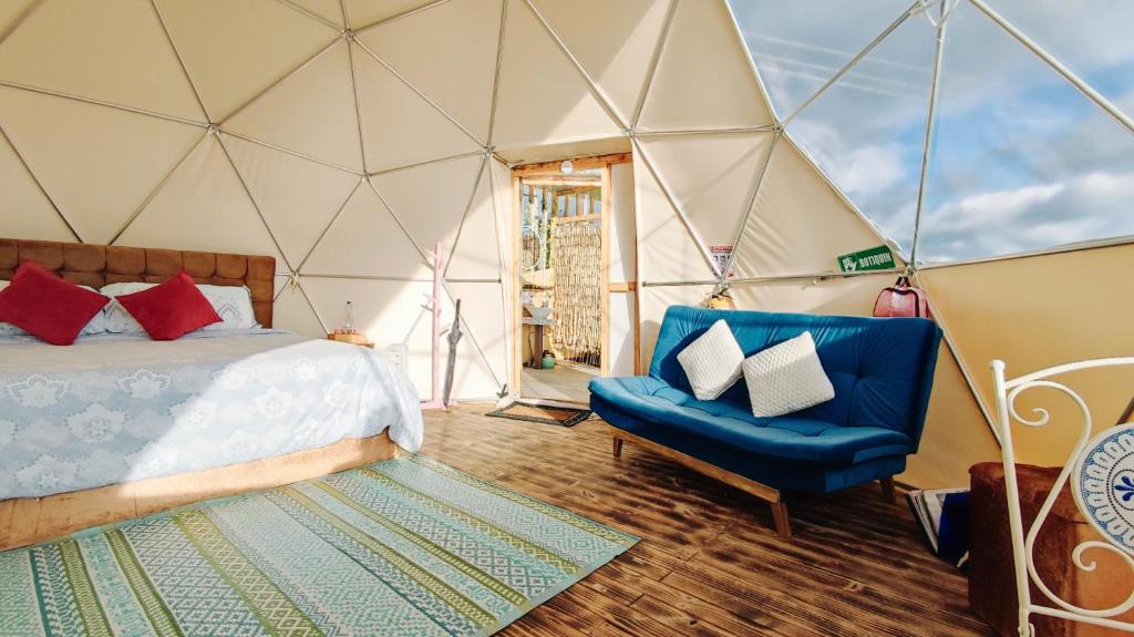Una habitación con una cama y una silla en una tienda de campaña en Andes Glamping, en Guatavita