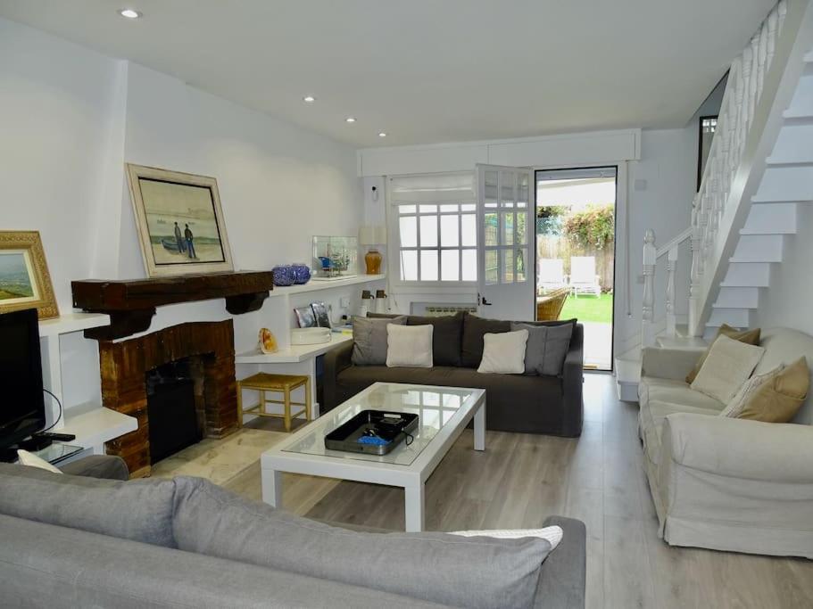 uma sala de estar com um sofá e uma mesa em Villa Familiar con encanto em Hondarribia