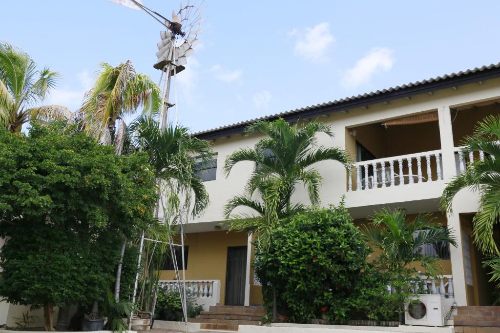 a building with palm trees in front of it at Hersher Studio's & Apartments in Willemstad