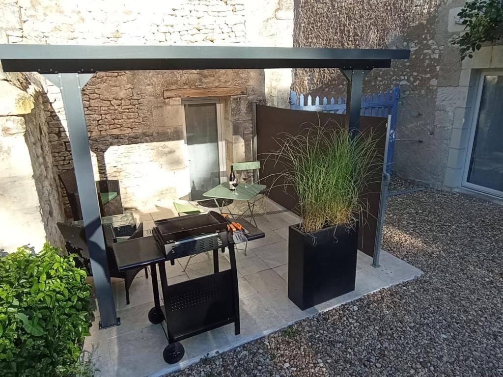 a pergola with a table and a plant in it at L'instant Civray in Civray-sur-Esves