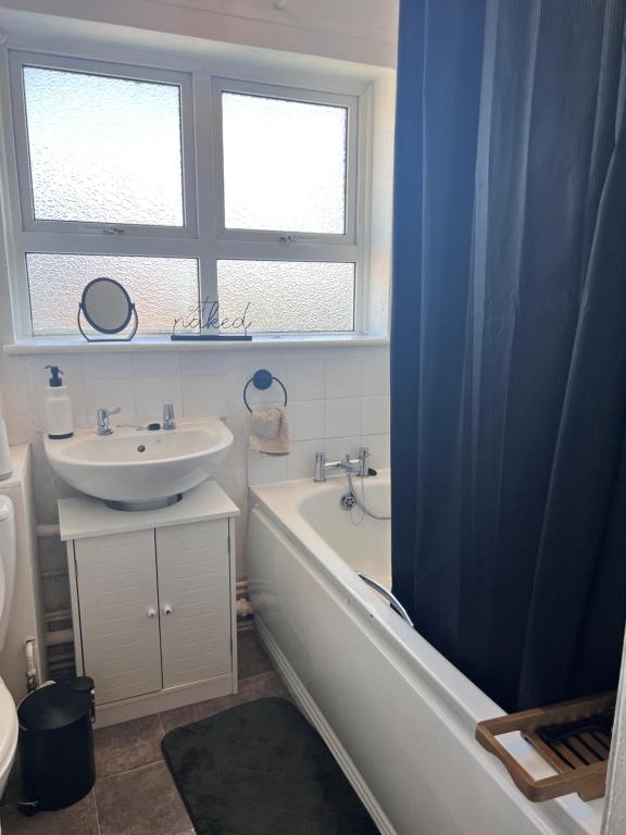 La salle de bains est pourvue d'une baignoire, d'un lavabo et d'une fenêtre. dans l'établissement Luxury 1bed Flat,Southend-on-sea, à Southend-on-Sea
