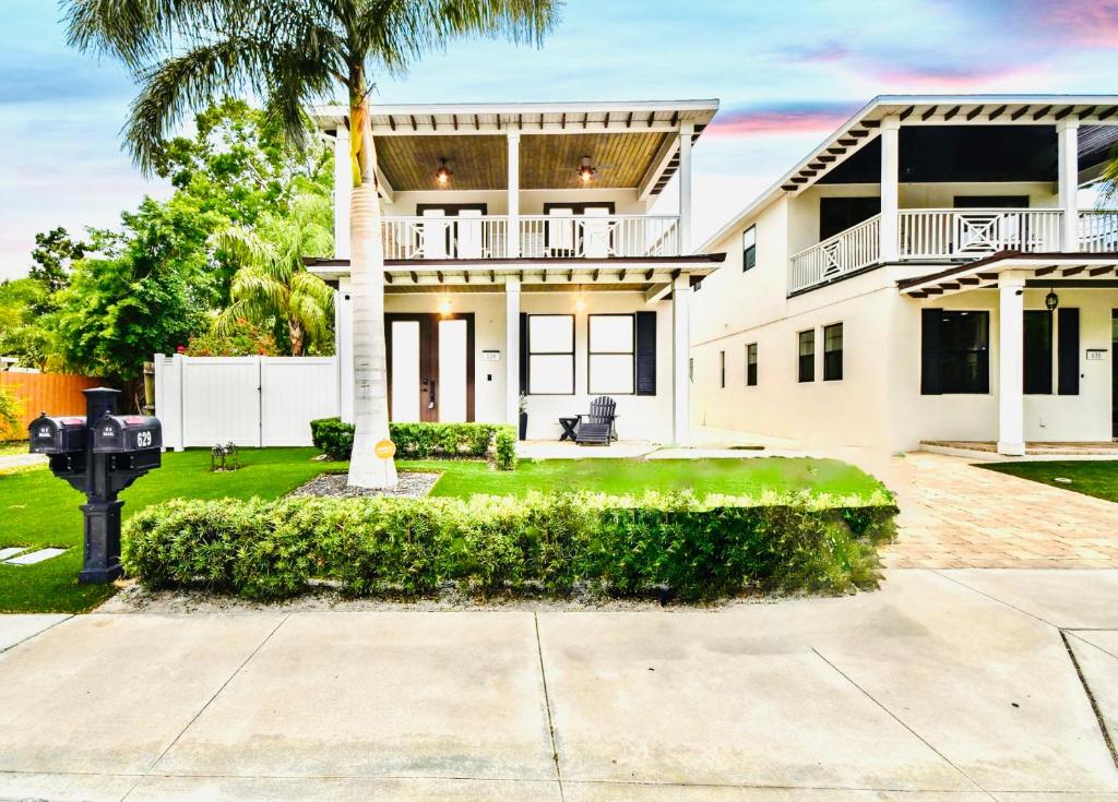 una casa blanca con una palmera delante de ella en Beach-town Pet-Friendly Downtown Home @ 10 acre Park-629 en Sarasota