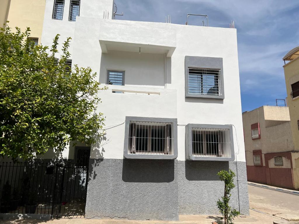 un edificio blanco con dos ventanas y una valla en sweet house fes, en Fez