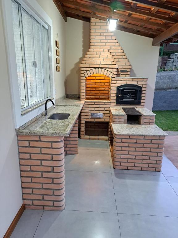 a outdoor kitchen with a brick pizza oven at A Casa do Júnior em Visconde de Mauá in Visconde De Maua