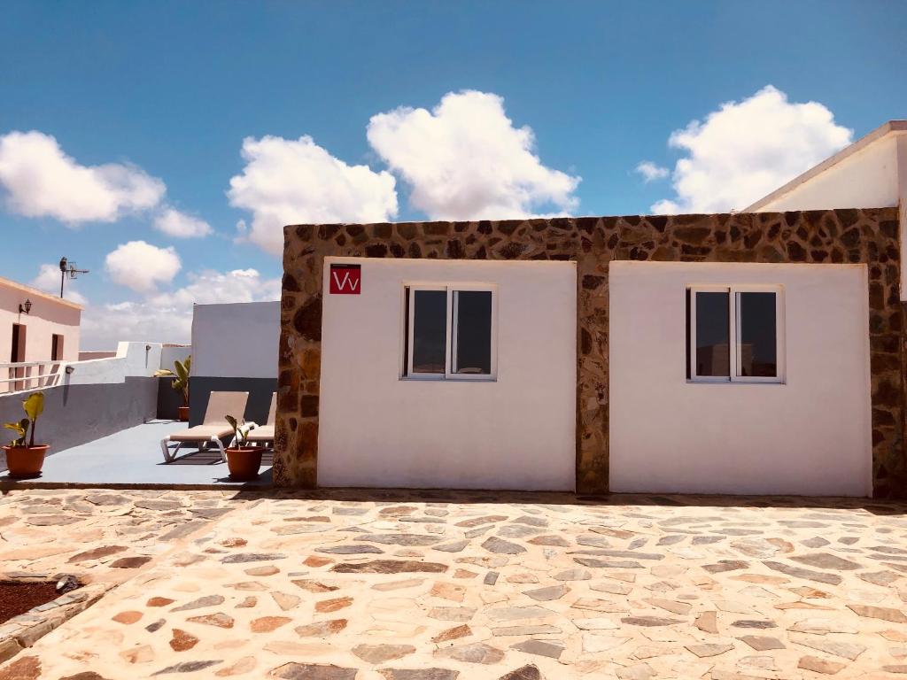 a building with two white doors on a patio at Mar y Montaña Apartamento entero in La Costa