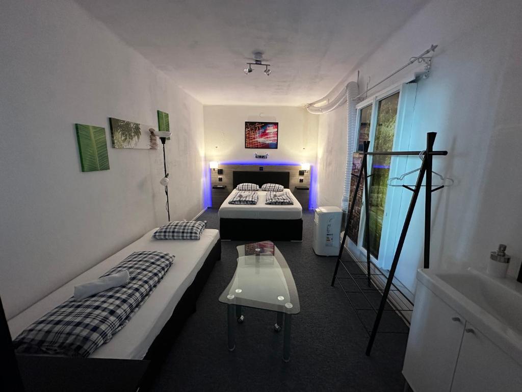 Habitación con 2 camas y mesa. en HOSTEL LOVELY ROOMS, city center, shared Bathroom, windows to corridor, en Villach