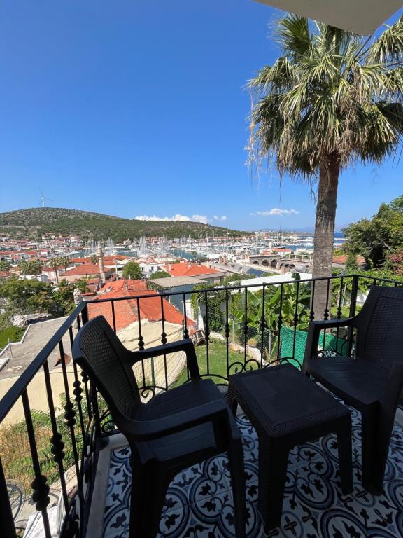 a balcony with two chairs and a palm tree at Villa Veria in Çeşme