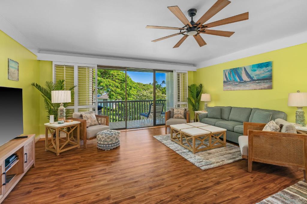 a living room with a couch and a ceiling fan at Step to beach New Quiet Kiahuna Plantation Remodeled 2 bedroom condo with AC in Koloa