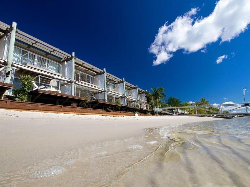 a building on the beach next to the ocean at Driftwood Apartment 6, Noosaville in Noosaville