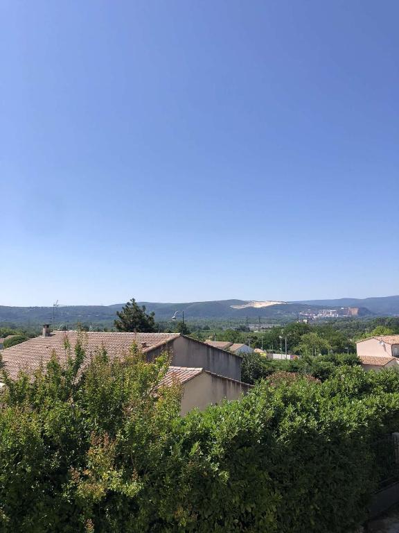 uma vista para uma cidade com árvores e um céu azul em Chez Laurence et Pascal em Châteauneuf-du-Rhône