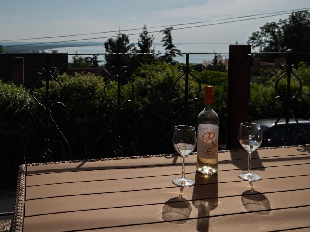 een fles wijn en twee glazen op een tafel bij Martour-ház in Fonyód
