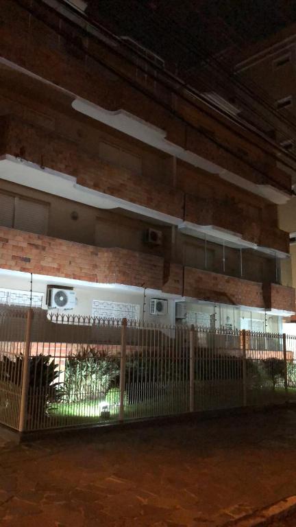 ogrodzenie przed budynkiem z ceglaną ścianą w obiekcie excelente apartamento completo w mieście Pelotas