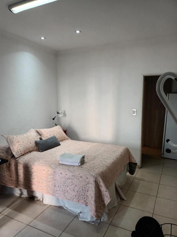 1 dormitorio con 1 cama con manta rosa en Kaedo en Corrientes