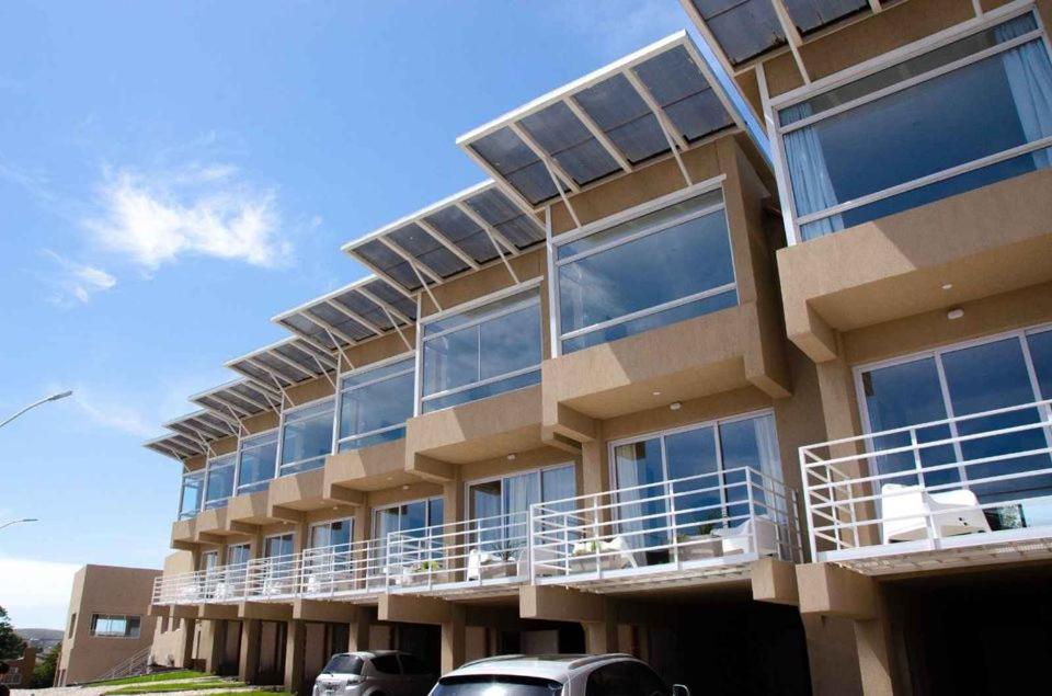 a building with balconies and cars parked in front of it at Hermoso Triplex en Sierra de la Ventana in Sierra de la Ventana