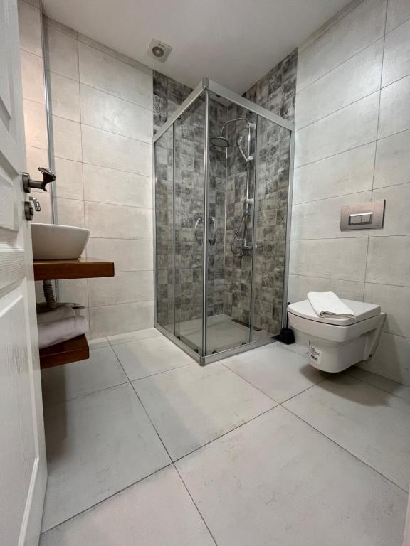 a bathroom with a shower and a toilet and a sink at Villa Veria in Çeşme