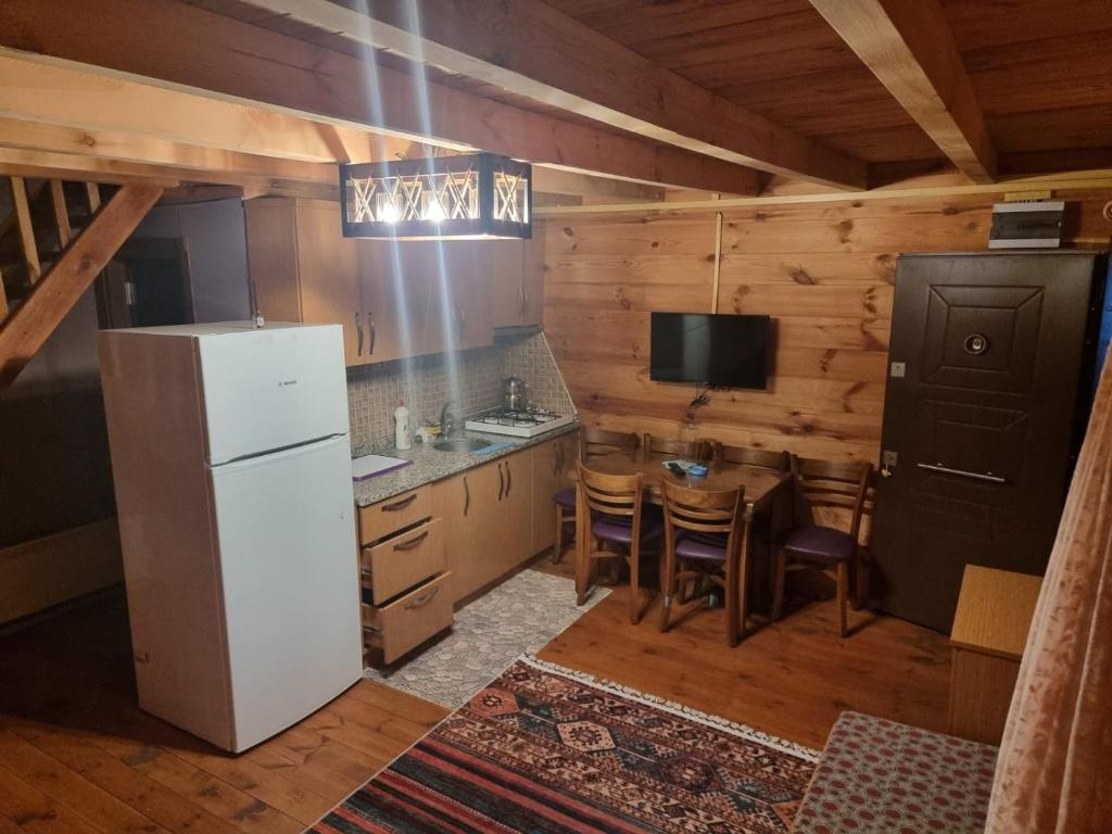 a kitchen with a refrigerator and a table with chairs at Ayder Rainbow Gokkusagi in Ayder Yaylasi