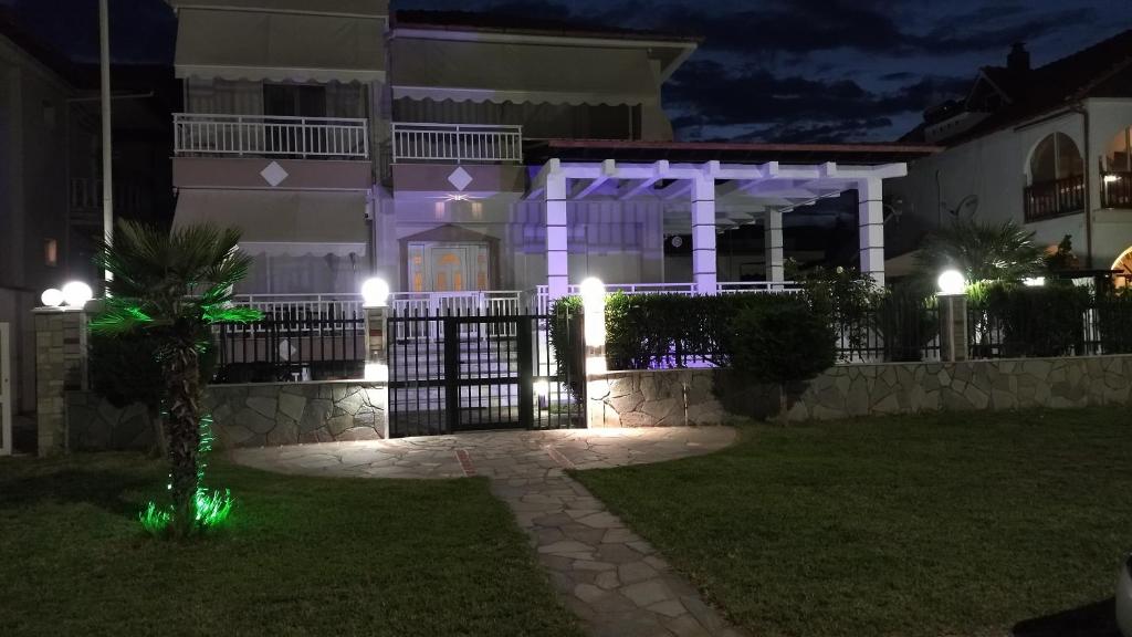 a house with a gate at night with lights at Seaview Apartment & semi basement seaview Apartment in Nea Vrasna